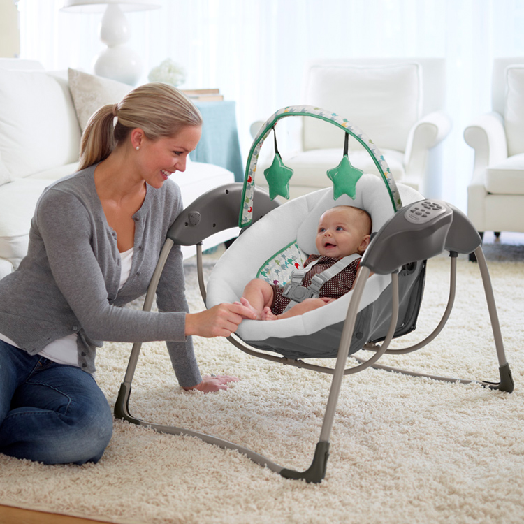Woman playing with baby in Graco Glider Lite swing