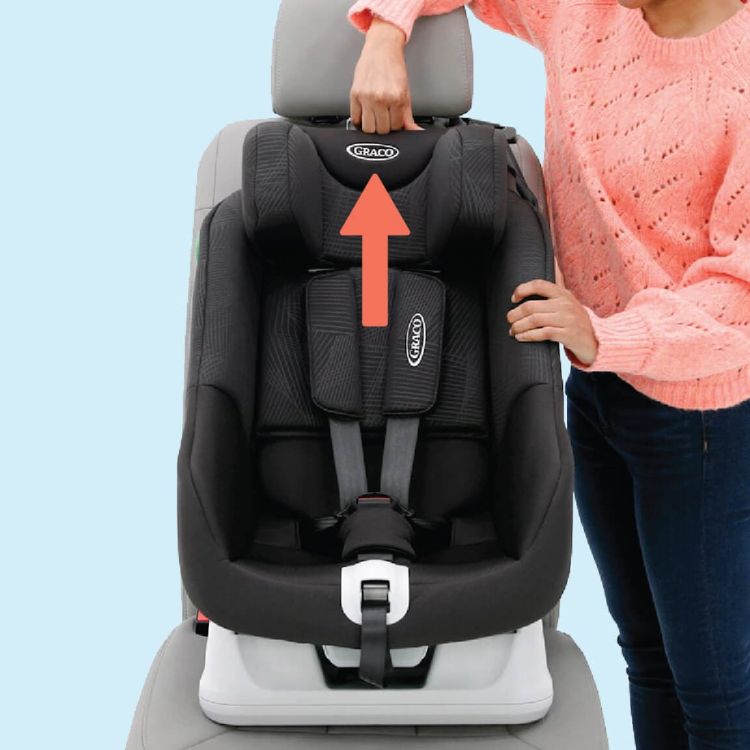 Woman's hand pulling up the no-rethread harness of the Graco Extend LX R129 car seat